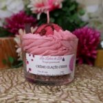 Bougie chantilly rose avec une boule de glace rouge, un coulis marron et un crumble en fond de pot