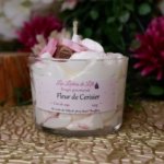 bougie chantilly blanche avec des petites fleurs rose et une branche marron pour rappeler les branche fleur du cerisier