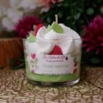 Bougie chantilly blanche avec un fond vert, des fraise et feuilles de menthe sur le dessus