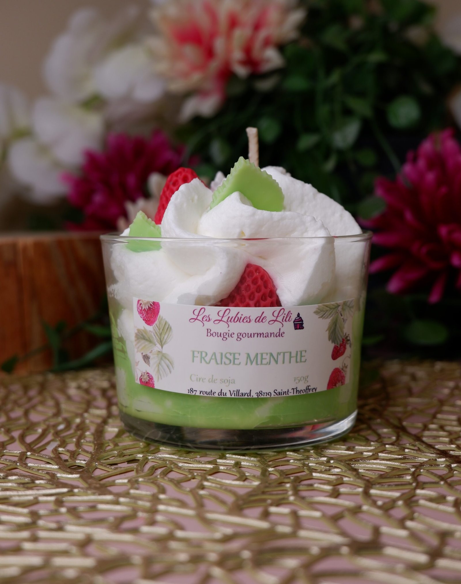 Bougie gourmande avec des fraises rouge, des feuilles et de la chantilly, senteur fraise menthe, dans un pot en verre, idéale pour décorer une table ou offrir en cadeau.