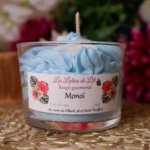 Bougie chantilly Monoï aevc une chantilly bleu, un fond blanc avec des paillettes et des fleur blanche sur le dessus