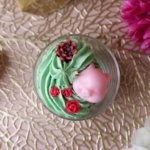 Bougie chantilly verte avec un lapin rose et des roses rouges