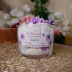 Bougie artisanale gourmande au parfum violette avec chantilly blanche et fleurs violettes en décoration, fabriquée à la main.