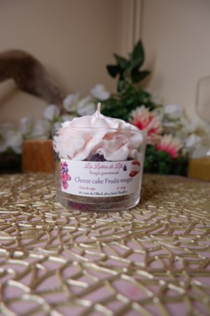 Bougie parfum cheesecake aux fruits rouges, avec une base biscuit, une couche de chantilly rose pâle et des fruits rouges à l'interieur